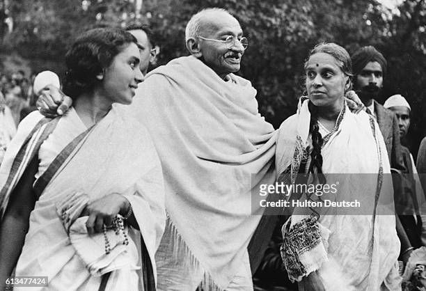 The Indian leader Mahatma Gandhi leaves his Simla residence for Wardah, helped by his doctor, Sheila Nayyar , and Susila Ben .