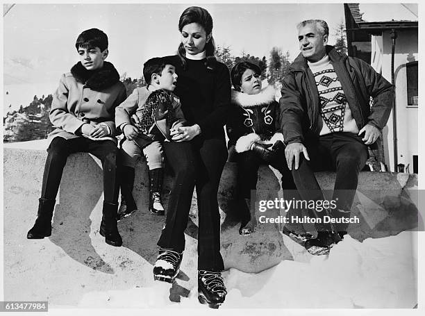 The Shah of Iran sits with his wife, the Empress Farah Diba of Iran, and children Prince Reza, aged 8, Prince Ali Reza, and Princess Farahaaz, aged 5.