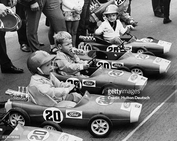 Rene Belso , aged 5, with Roger Duckworth , aged 4, and Amanda McLaren, aged 3 1/2, seated behind the wheels of miniature, pedal-driven, Lotus-Ford...