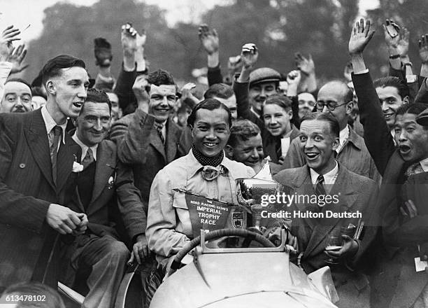 Crowd of people congratulate Prince Bira of Spain, after he won an International Car Race.