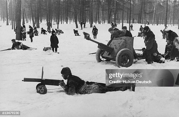 Soviet schoolchildren dressed in camouflage clothing learn how to use weapons, and other war-fighting tactics in Sokolniky Park.