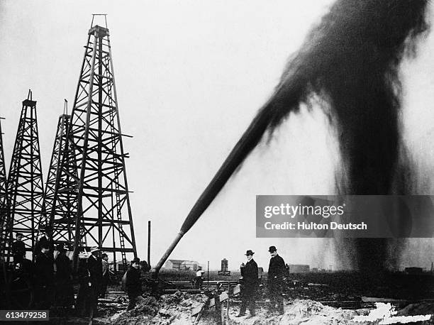 Stream of crude oil shoots into the air from an oil well.