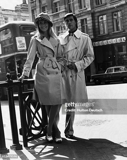 Top London models wear raincoats from the 1974 spring collection of the classical clothing company, Burberry's. The woman models Glenco while the man...