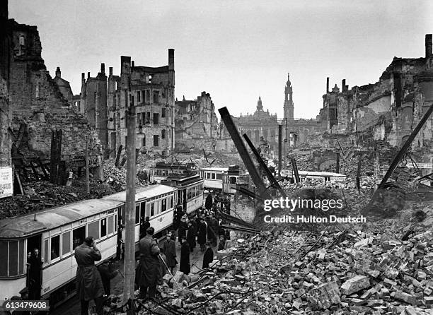 Dresden citizens in the Soviet sector of Germany attempt to get on trams amidst the ruins and chaos remaining since the city was reduced to ruins by...
