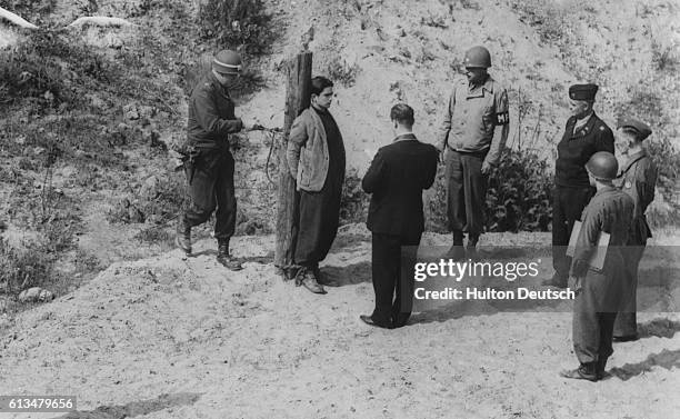 Military police tie a member of the Hitler Youth to a stake. The 17 year-old boy will be executed by firing squad for spying on US troops. |...