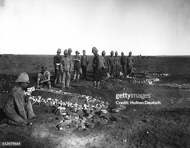 Soldiers decorating the graves of dead officers at Modder River. | Location: Modder River, South Africa.