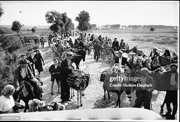 Fear of an attack by guerillas makes Greek peasants travel together in a convoy to the town market during the Civil War of 1944-1945.