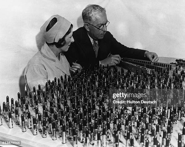 Max Factor the Russian-born cosmetics magnate examines lipsticks with Ray Judd at his factory in Hollywood, California, 1932.