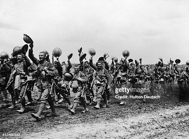 British soldiers from a battalion of Worcestershire Regiment raise their helmets for the camera as they head toward the trenches in France. |...