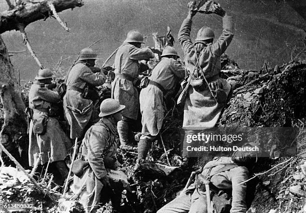 From their higher position, French troops use large stones and rocks to dislodge German soldiers from hillside trenches during World War I, possibly...