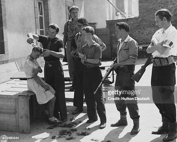 Group of young men shave the head of a young woman accused of collaborating with the Nazi occupiers of France. This will mark her so all will know...