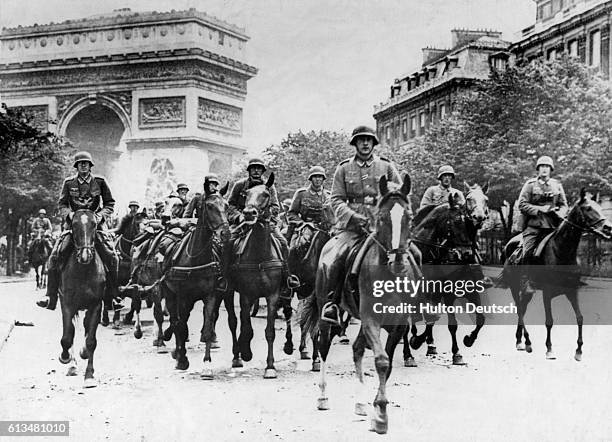 German cavalry soldiers ride through Paris in 1940 after occupying the city.