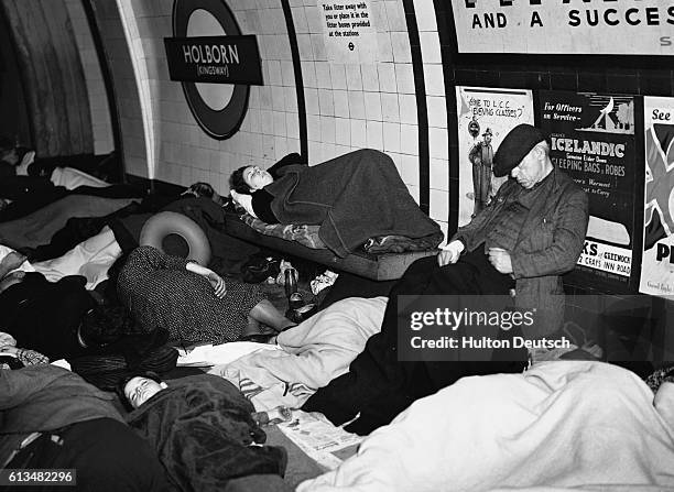 People sleeping whilst sheltering from air raids in Holborn tube station, 1940. | Location: Kingsway, London, England, UK.