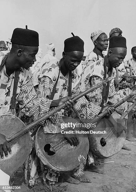 Nigerian musicians greet the Queen during her 1956 tour, as they play their stringed instruments for her arrival in Kaduna. | Location: Durbar,...