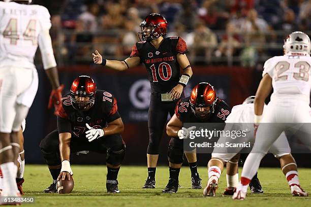 Christian Chapman of the San Diego State Aztecs makes a call from the line of scrimmage as Arthur Flores and Nico Siragusa prepare to play in the...