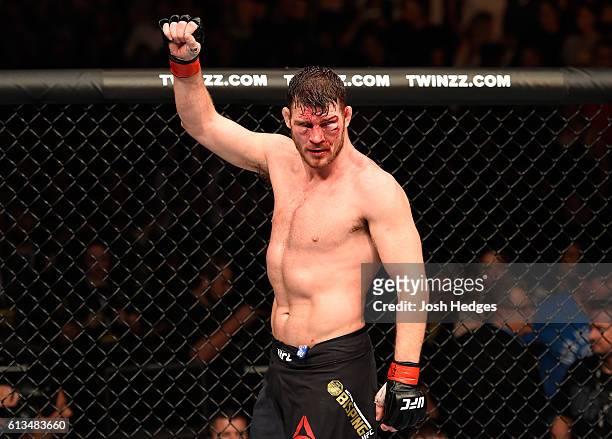 Michael Bisping of England raises his hand after facing Dan Henderson in their UFC middleweight championship bout during the UFC 204 Fight Night at...