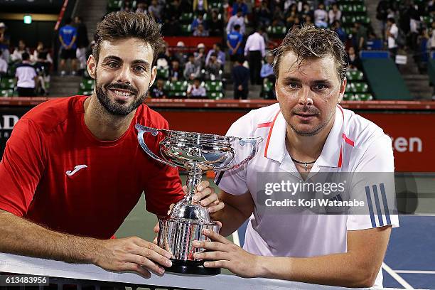 Marcel Granollers of Spain and Marcin Matkowski of Poland pose with a trophy after winning the men's doubles final match against Raven Klaasen of...