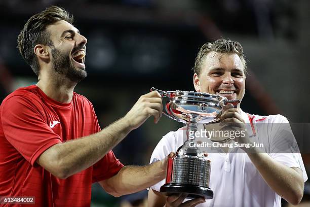 Marcel Granollers of Spain and Marcin Matkowski of Poland pose with the trophy after winning the men's doubles final match against Raven Klaasen of...