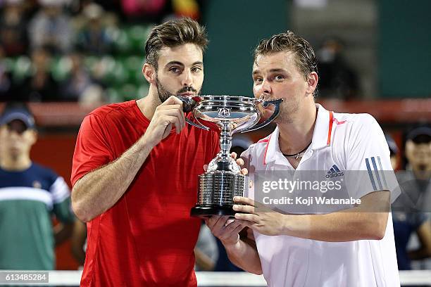 Marcel Granollers of Spain and Marcin Matkowski of Poland pose with a trophy after winning the men's doubles final match against Raven Klaasen of...