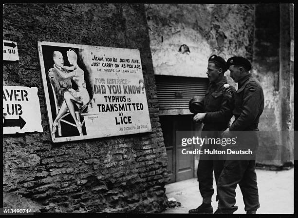 Lance Corporal Tom Gargetty and Trooper Gordon Roddie read a poster warning of the danger of catching typhus from lice.