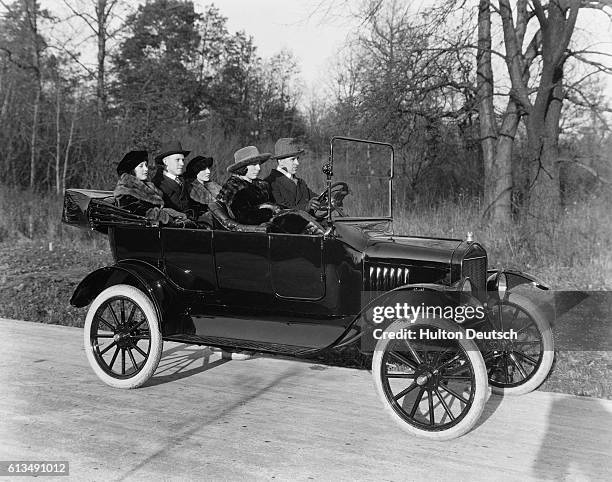 Group of people driving in a Ford Model T automobile in the 1920's.