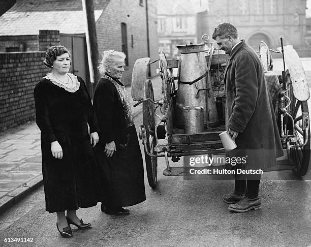 Milkman stands with his two customers as they respect the two minutes silence.