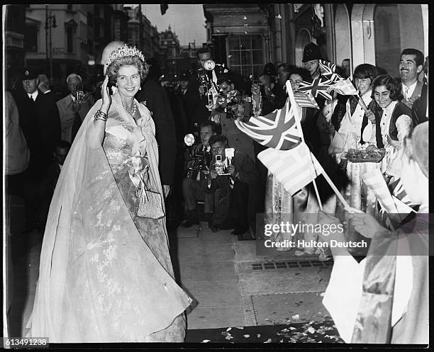 Queen Frederika of Greece waves to well-wishers as she arrives with her husband, King Paul, at Claridge's Hotel where the couple are hosting a...