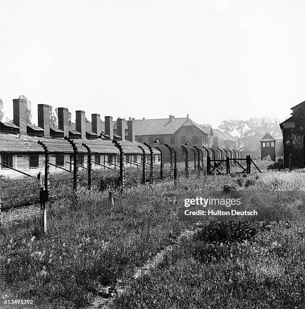 View of Auschwitz-Birkenau concentration camp. Two rows of barbed wire encircle the camp. The path between could be easily machine-gunned from the...