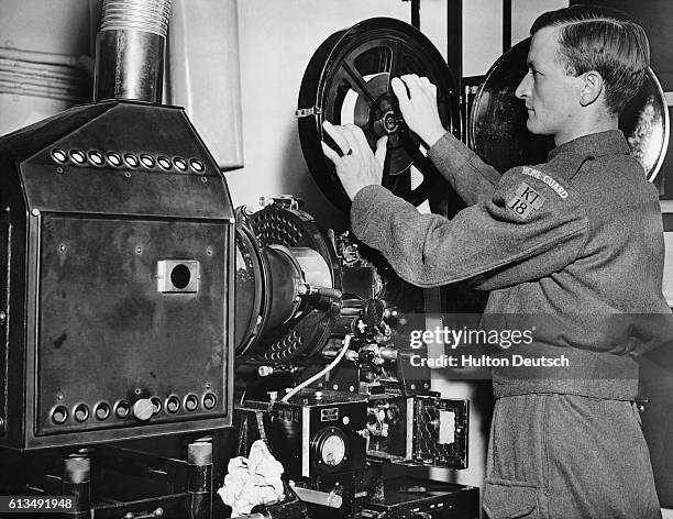 Home Guard cinema projectionist at work. Ten thousand cinema managers and projectionists have been recruited by the Home Guard so that British...