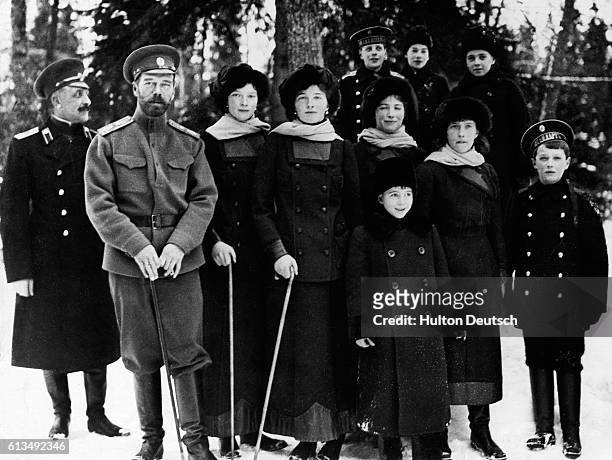 Nicholas II, the last Czar of Russia, stands outdoors at Tsarskoye Selo with his children and nephews near or just after the time of his abdication...