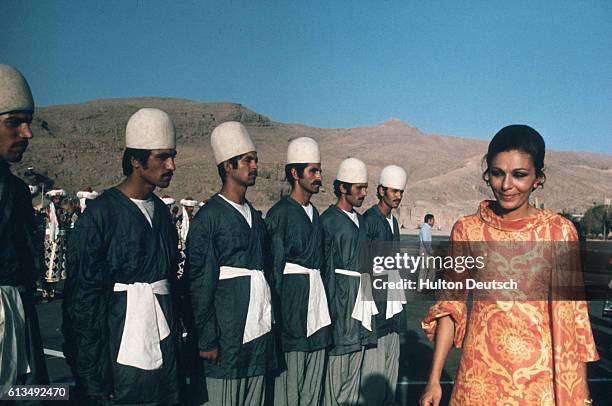 Empress Farah Diba of Iran inspects a row of soldiers in preparation for festivities celebrating the 2500th anniversary of the Persian Empire.