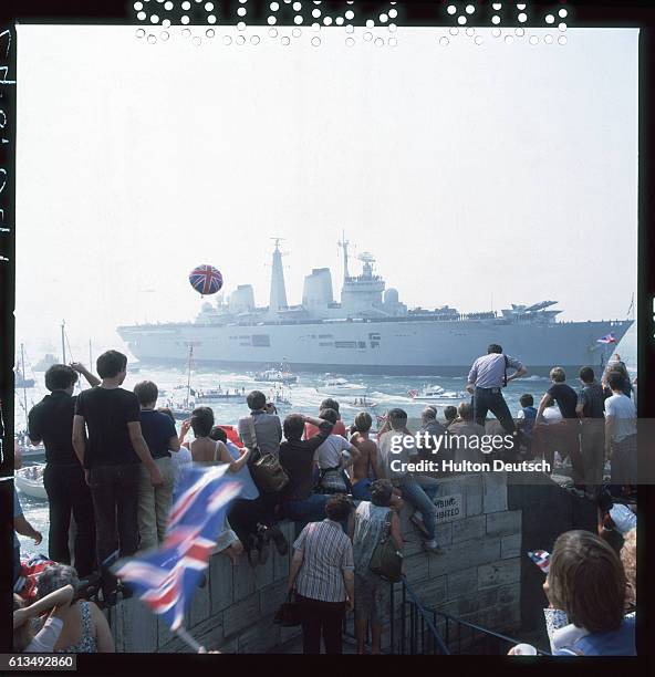 Crowd of spectators watches the warship HMS Invincible after her return from the Falklands War.