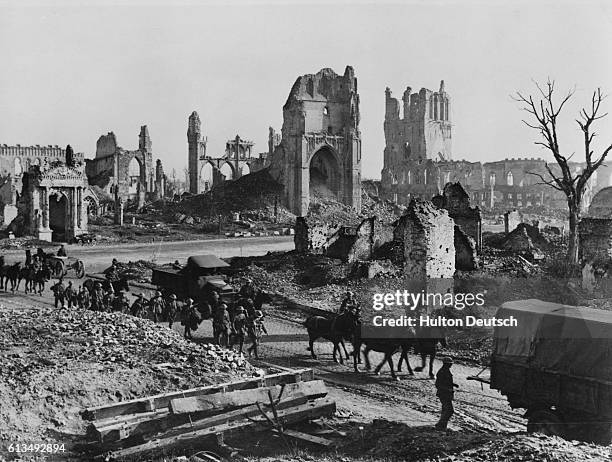 Convoy of horses and wagons pass by the ruins of St. Martin's Church and the Cloth Hall of Ypres. The city was almost totally destroyed in the long...