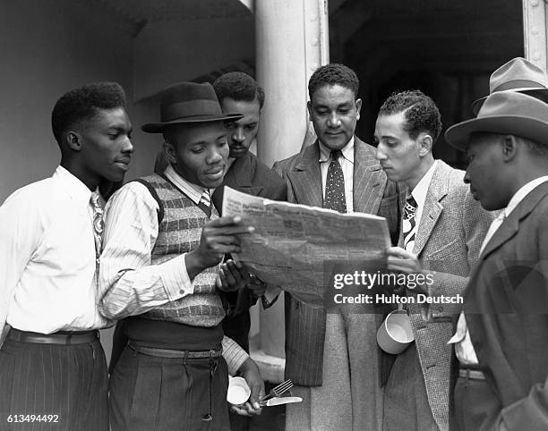 Group of men reading the news aboard the HMT Empire Windrush on arrival at Tilbury in Essex, 22nd June 1948. They are among the first immigrants from...