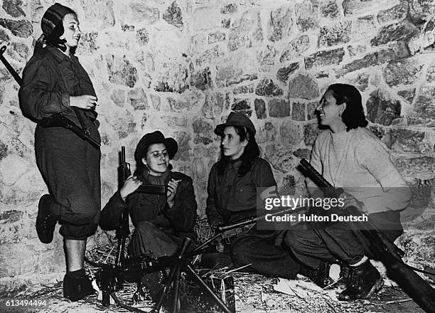 Four anti-Fascist Italian women patriots helping the Allies near Castellucio relax and check their weapons as they wait for orders.