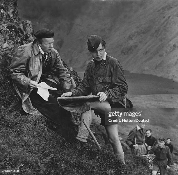 An instructor from the Sea School's course at the Aberdovey Outward Bound School asks one of his students to pinpoint their position on a map during...