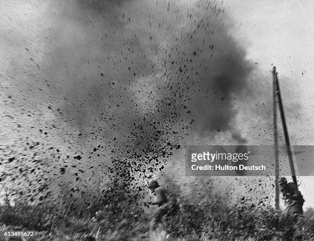 American paratroopers involved in an assault on Arnhem during World War II run through a muddy field under heavy German artillery fire.