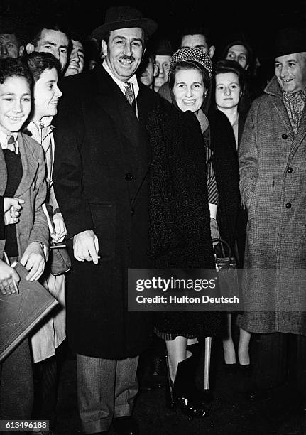 Film producer and cartoonist Walt Disney arrives at Waterloo Station with his wife, 1946. | Location: Waterloo, London, England, UK.