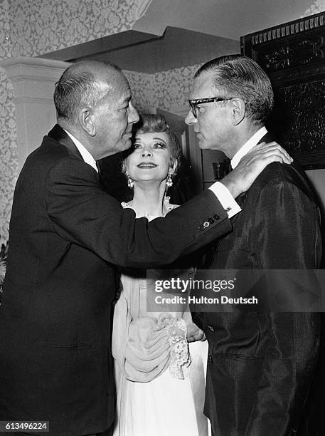 Noel Coward greets Vivien Leigh and Laurence Olivier in the lobby of The New Theatre.