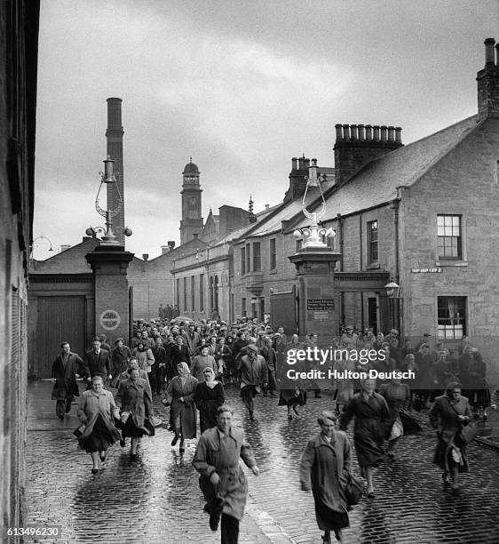 Workers leave the Campendown Mills in Dundee, Scotland.