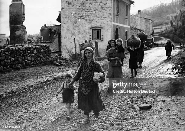 Taking their children with them, Italian women evacuate their village during World War II .