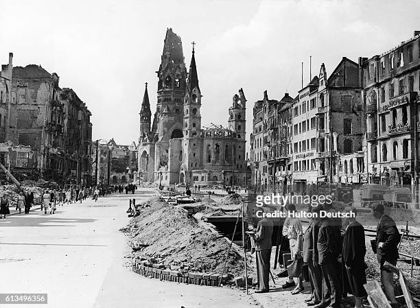 Germans watch an artist painting the battle-scarred streets of Berlin including the Kaiser Wilhelm Memorial Church in Tauenzien Strasse. | Location:...