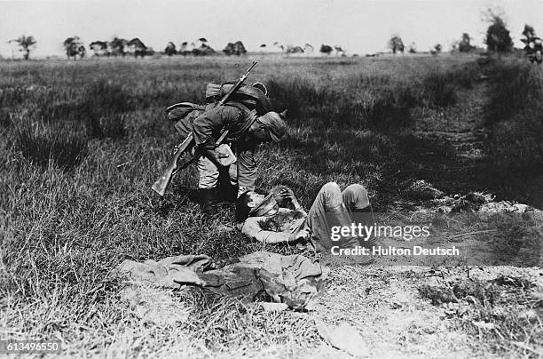 German soldier gives a wounded Russian a drink on a battlefield at Galicia, June 13, 1915. | Location: Galicia.