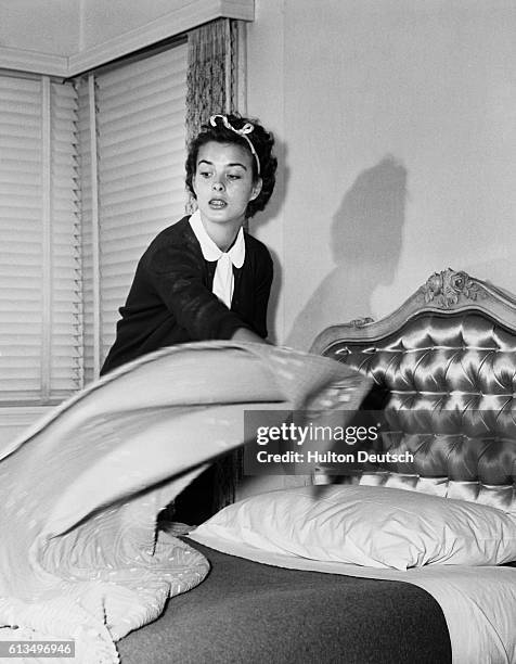 The young Hollywood actress makes a bed.