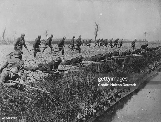 First World War Belgian troops run to take up position along the banks of a canal near the Ypres salient. In the first Battle of Ypres, October 1914,...