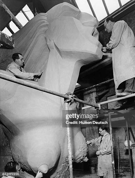 Sculptors work on a giant female clay figure by Barney Seale for the Chelsea Arts Ball at Royal Albert Hall in London.