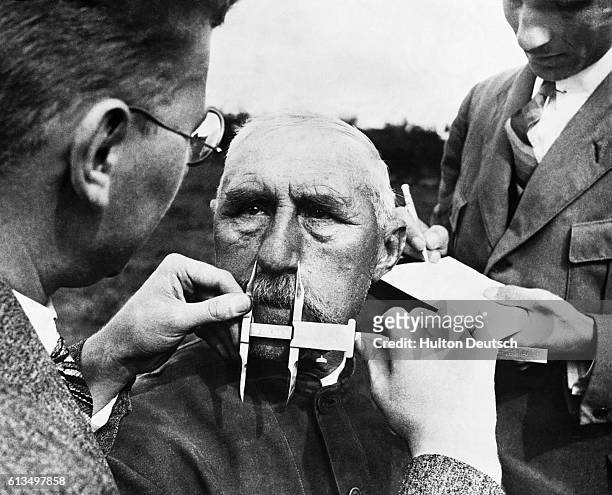 Nazi officials use calipers to measure an ethnic German's nose. The Nazis developed a system of facial measurement that was supposedly a way of...