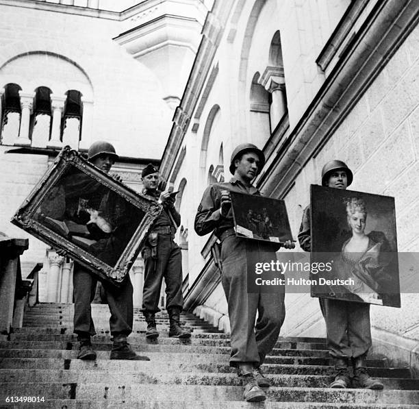 Soldiers from the 7th US Army carry three priceless artworks down the steps of Meunschwanstein Castle where hoards of European art treasures, stolen...