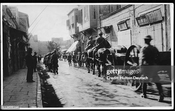 Palestinians look on a British troops march through the streets of Jerusalem, an area in dispute between Palestinians and Israelis regarding the...