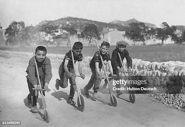 Children racing with the "rado", a Spanish version of the "kiddie-car", as frequently seen in provincial towns in Spain.